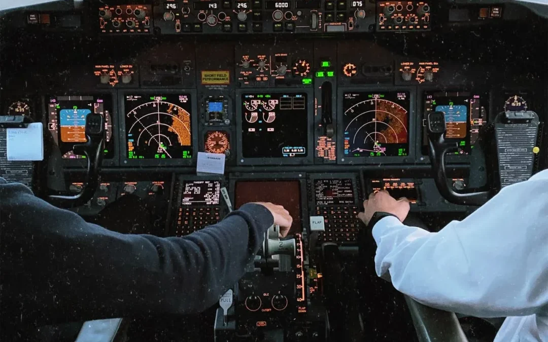 Two commercial airline pilots operating a flight in a modern aircraft cockpit simulator