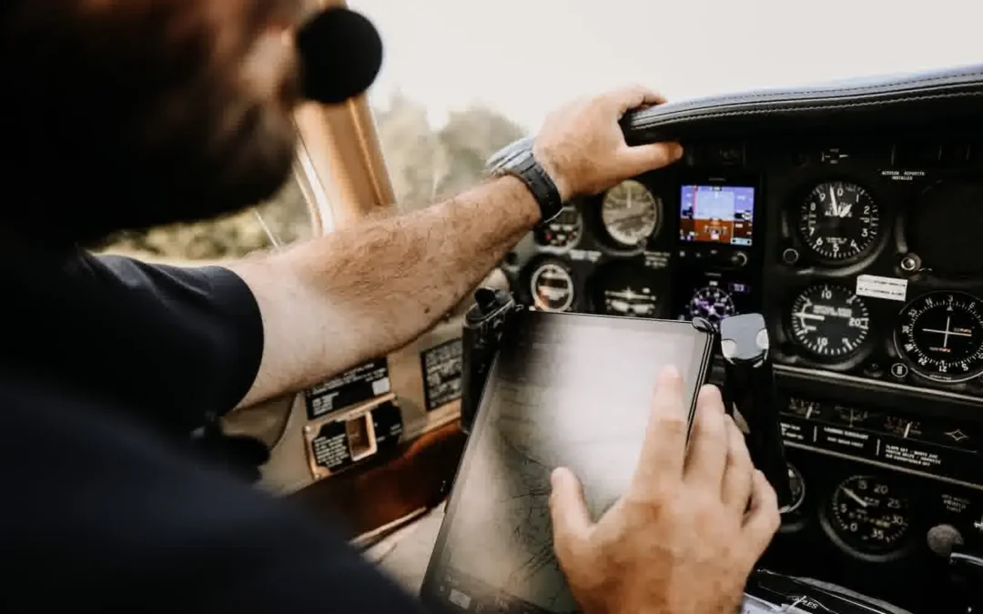 Professional pilot in cockpit using tablet for navigation